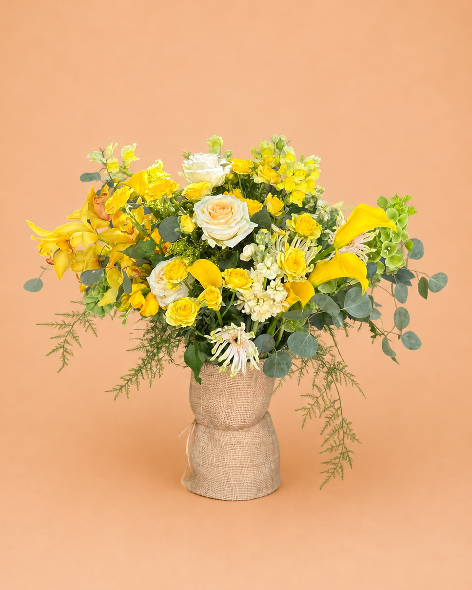 Bouquet of yellow and white flowers in a woven basket on a peach background