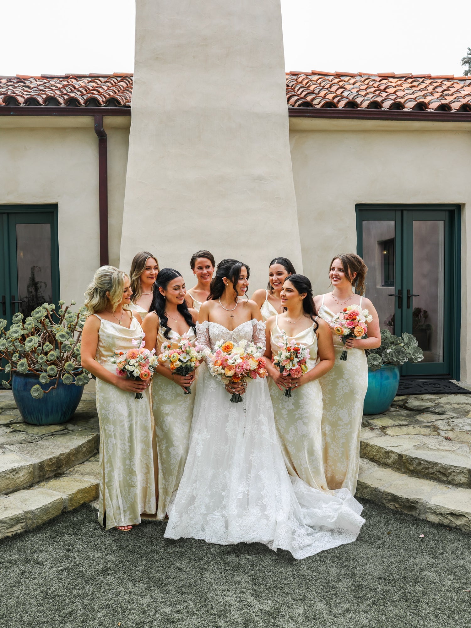 Group of women in elegant dresses standing together outdoors.